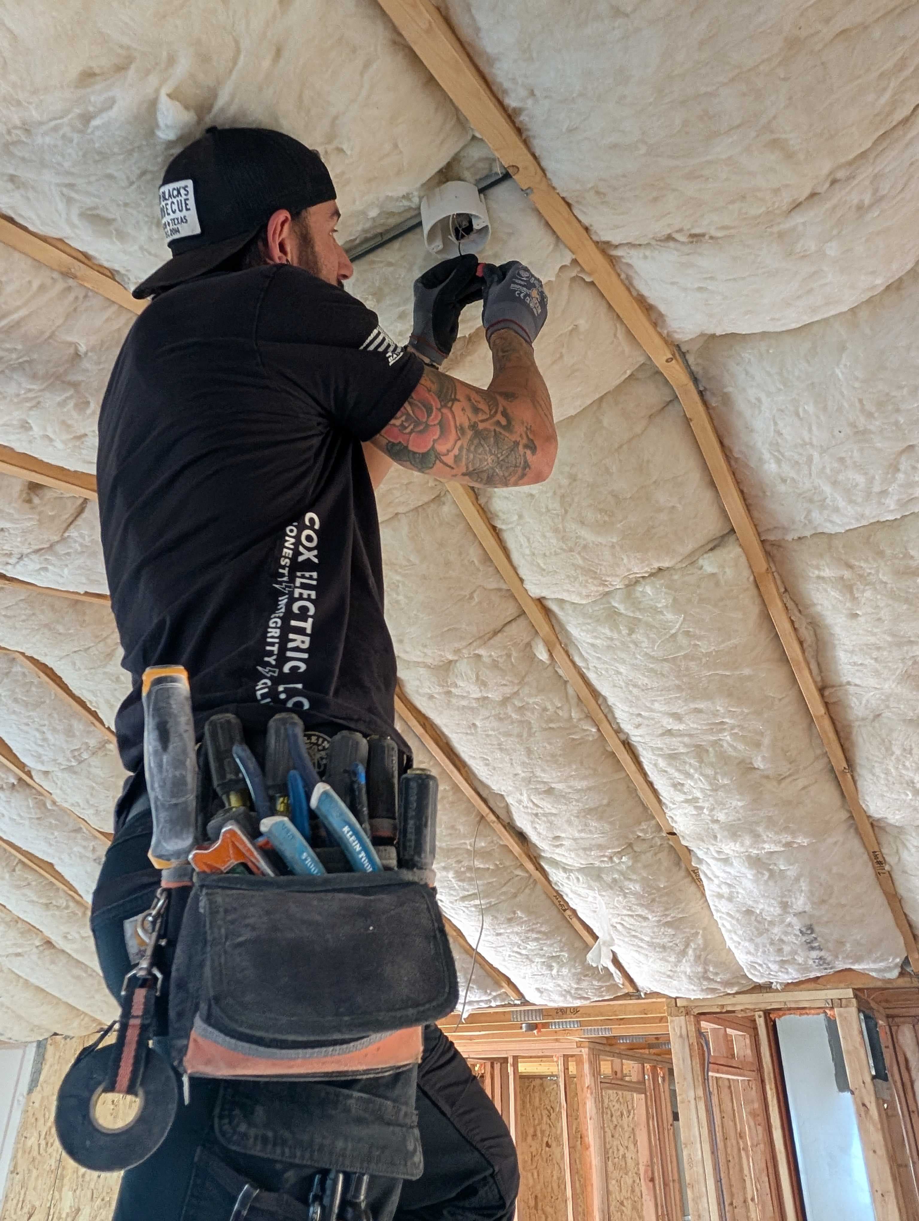 Avery wiring a ceiling box in a Cox Electric shirt