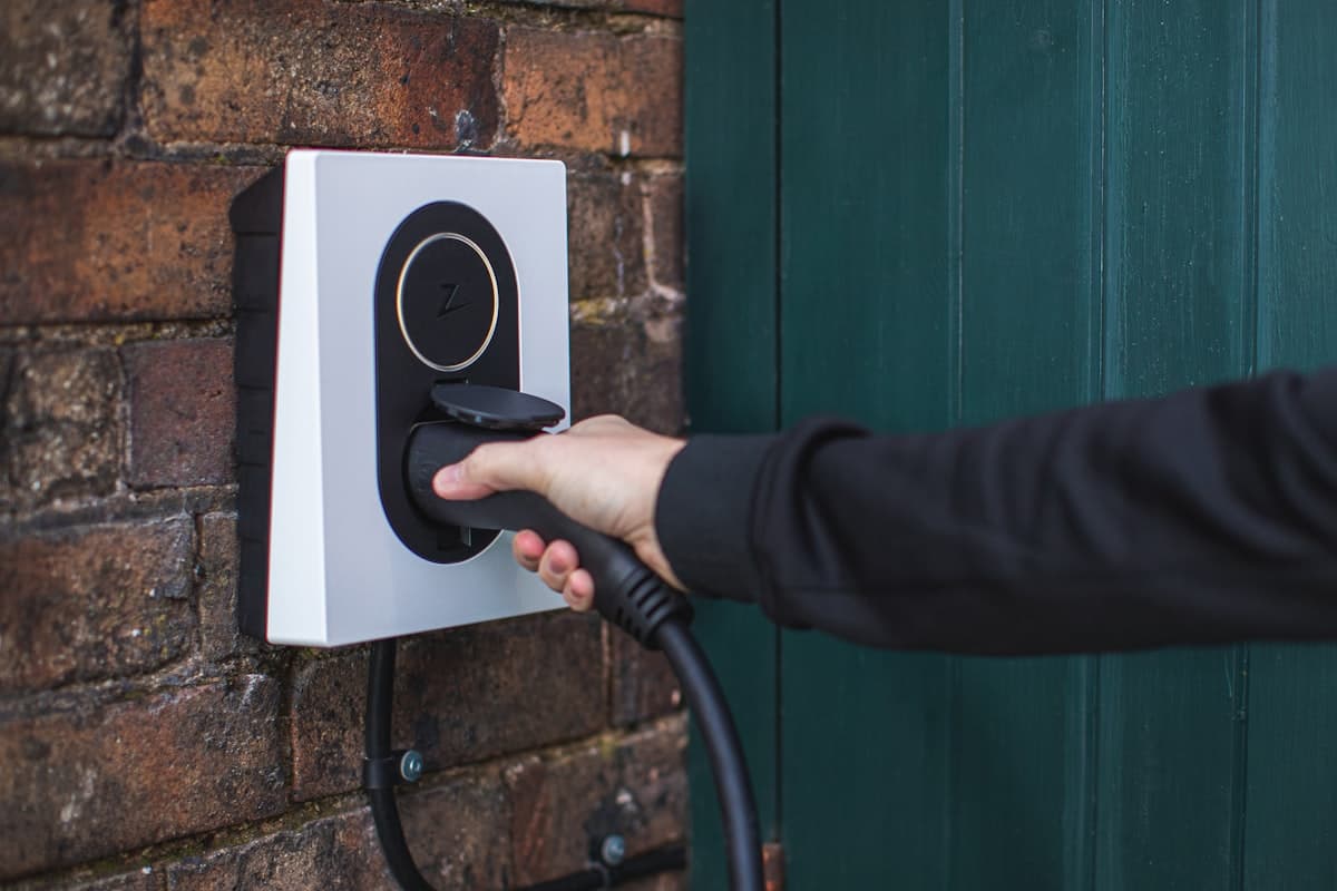 Wall-mounted home EV charger with charging plug